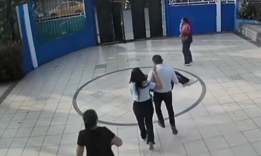 Toma de un video, donde la menor es retirada en brazos por un trabajador del centro educativo.